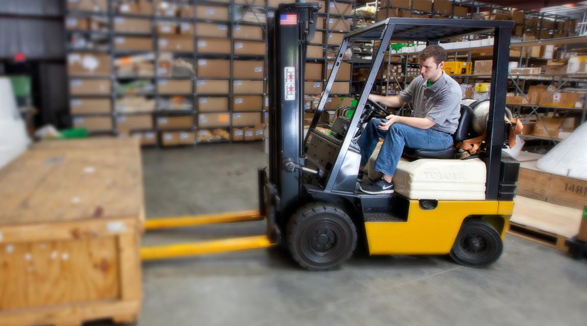 A man drives a forklift inside the Aventure Aviation main facility warehouse
