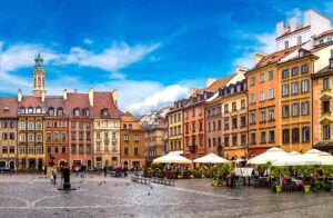 Old town square in Warsaw in a summer day, with cafes surrounded by historical buildings