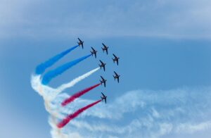 Eight jets of the French Air Force aerobatic demonstration team making red, white, and blue colred smoke traces in the sky during the Paris Air Show