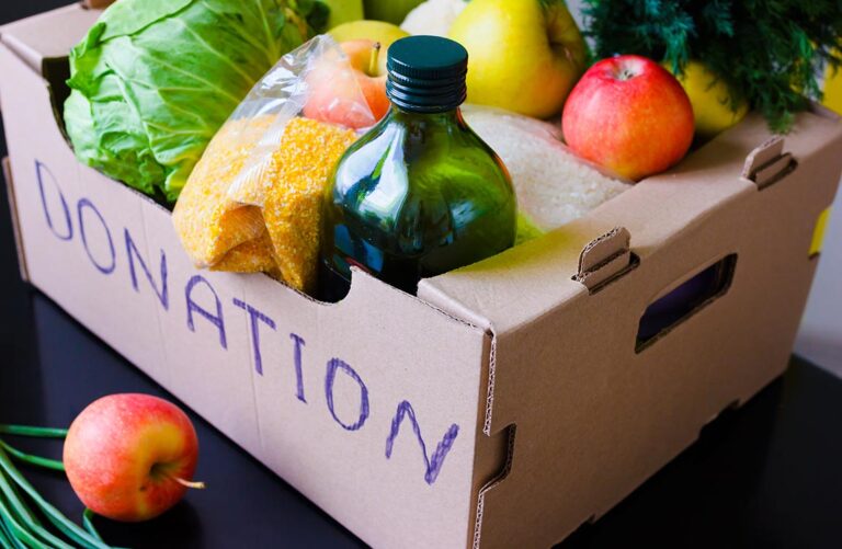 A cardboard box labeled "donation" containing produce and other food